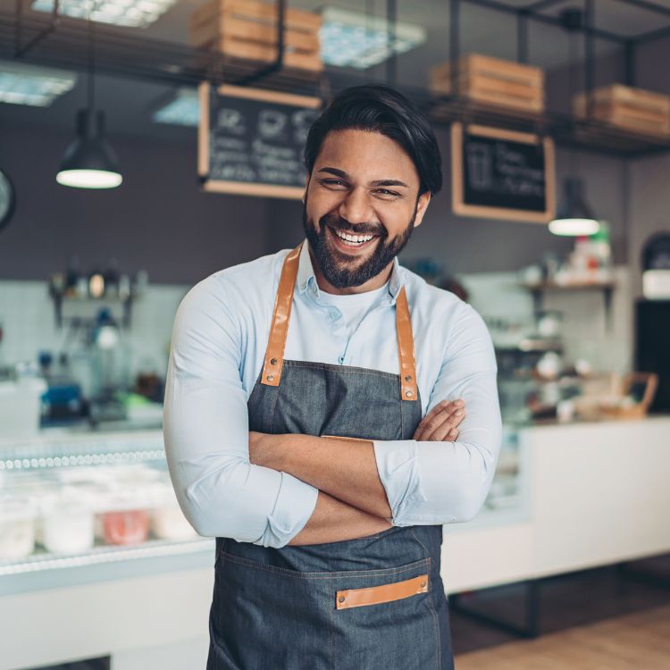 A cafe owner smiling at the camera